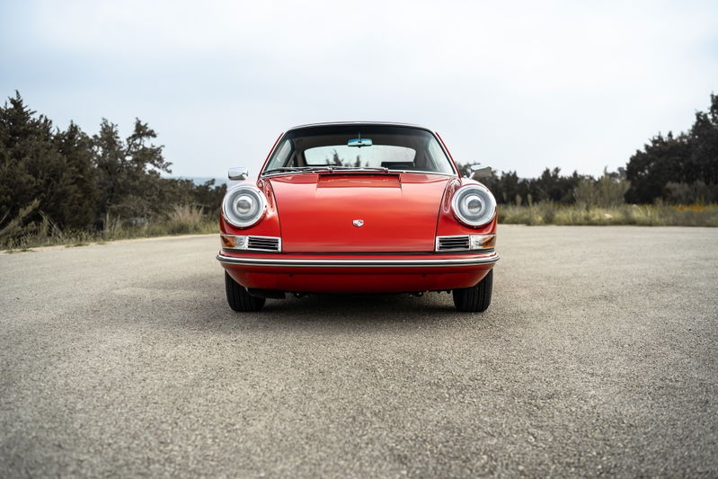Front view of a red 1967 Porsche 912 coupe with chrome trim and classic round headlights.