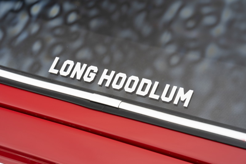White "Long Hoodlum" decal on the window of a red 1967 Porsche 912 coupe.