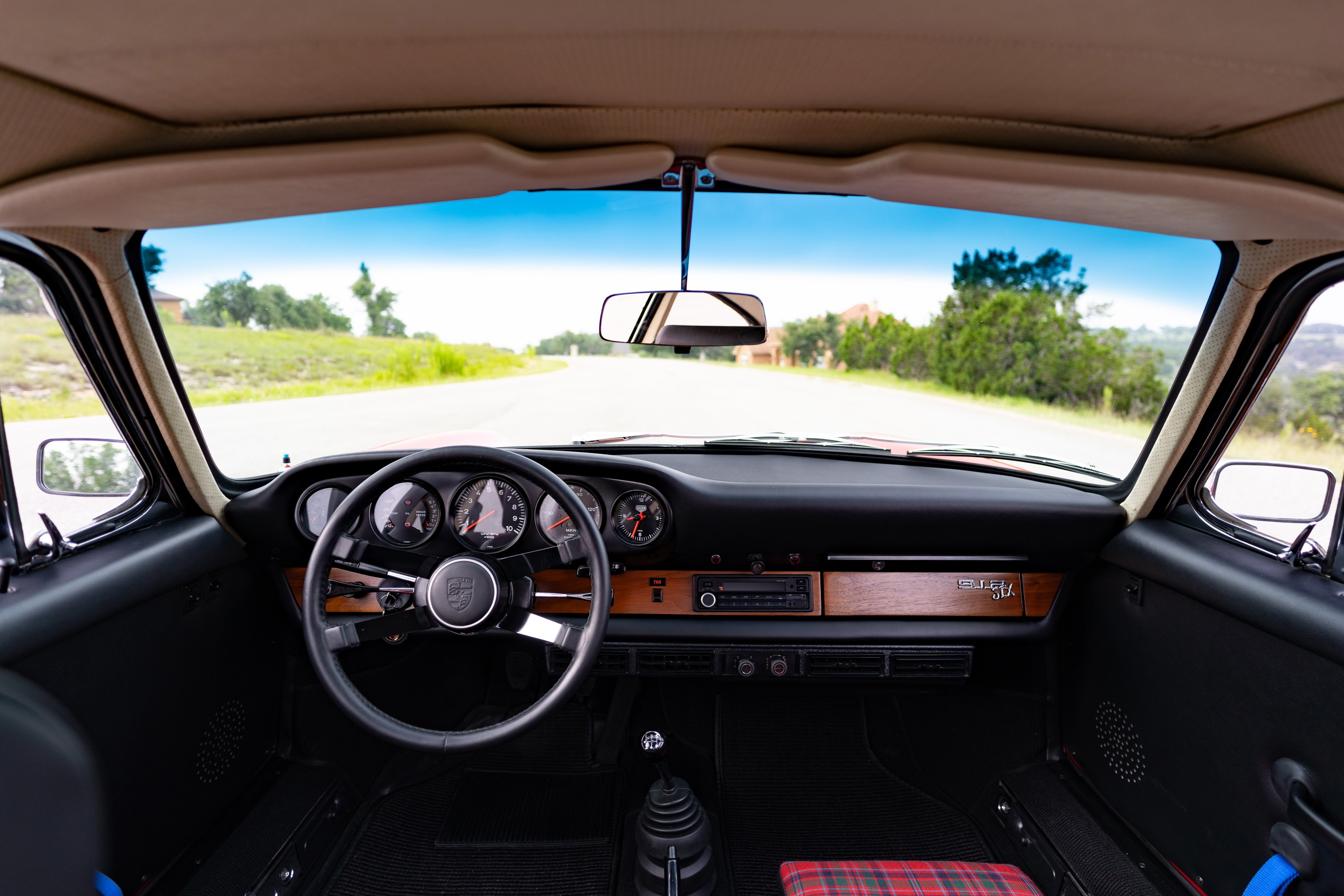 1967 Porsche 912 coupe interior: wooden trim, five-gauge dash, plaid seats.
