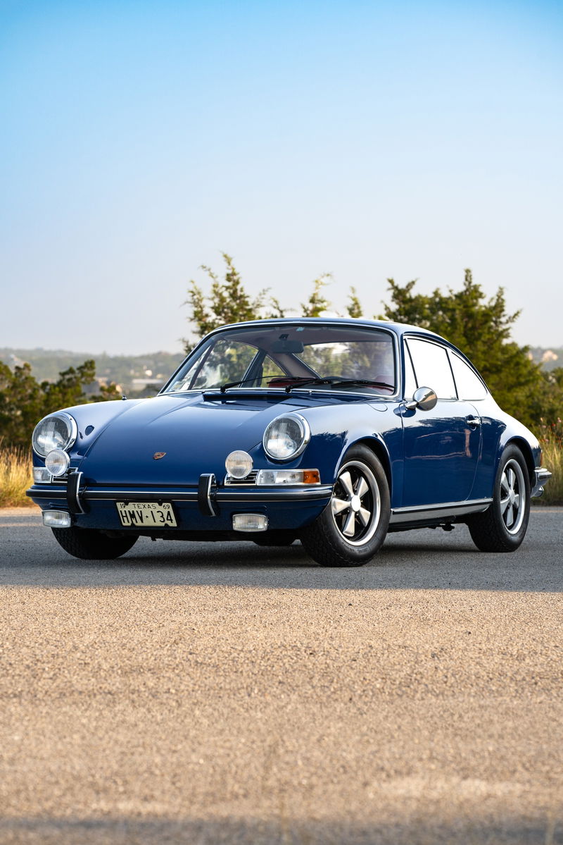 Blue 1969 Porsche 911S coupe with chrome trim and Fuchs rims.