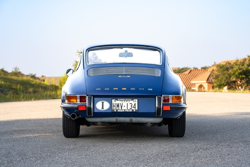 Rear view of a blue 1969 Porsche 911S with chrome trim and Fuchs rims.