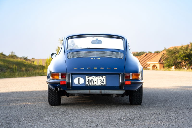 Rear view of a blue 1969 Porsche 911S with chrome trim and Fuchs rims.