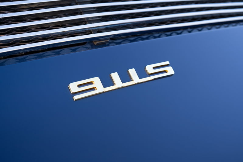 Gold "911S" badge on the dark blue metallic hood of a 1969 Porsche 911S.