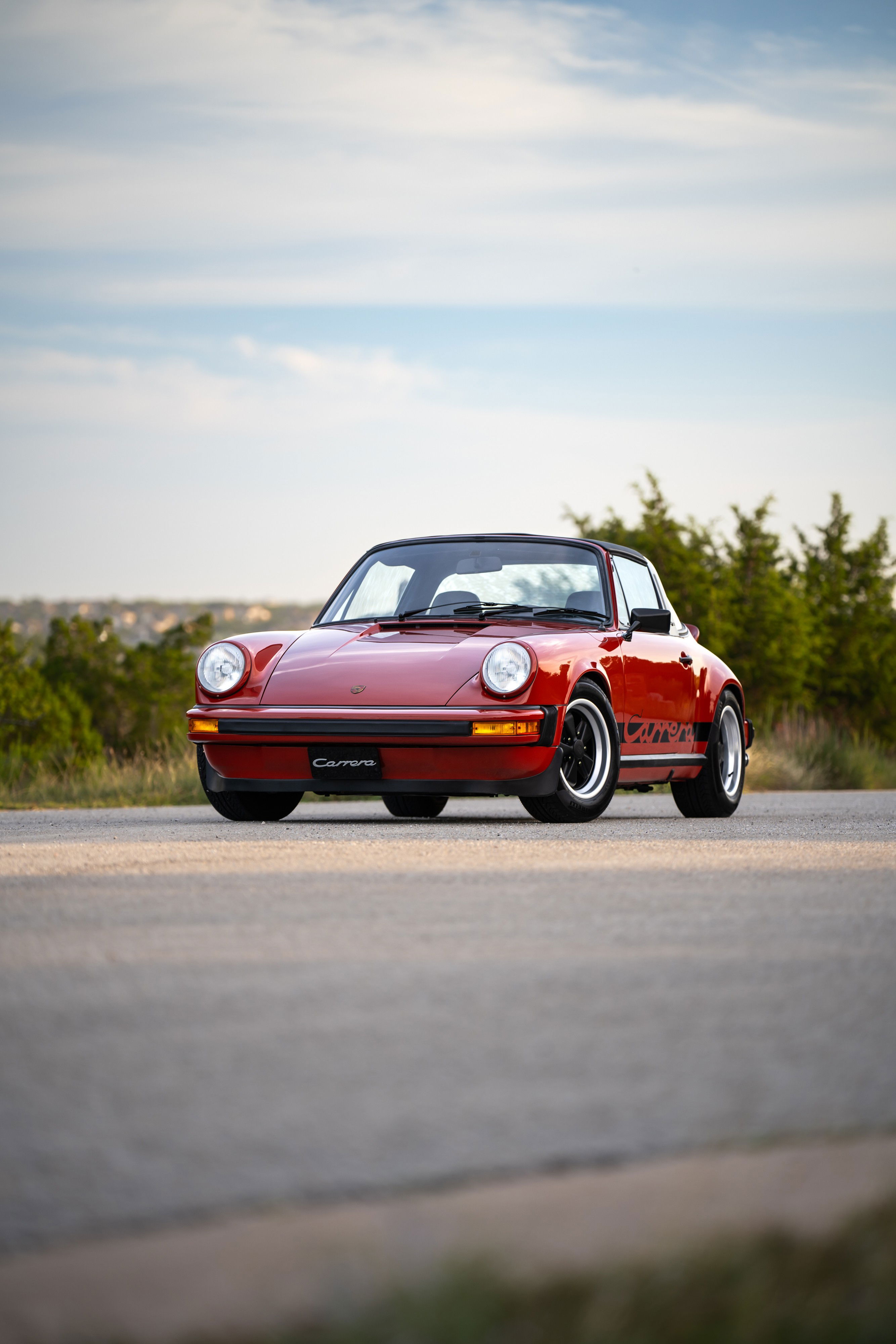 Red 1974 Porsche 911 Carrera Targa with black trim and Carrera side livery.