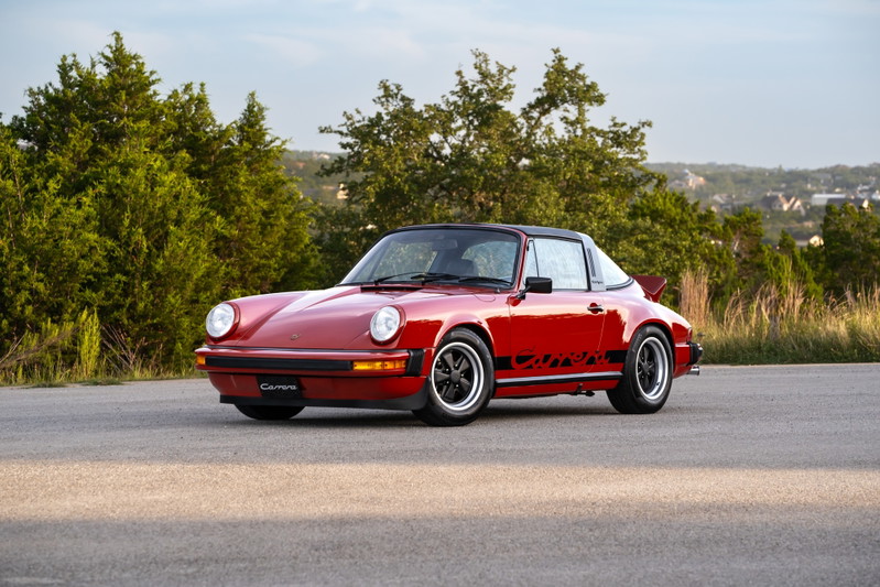 Red 1974 Porsche 911 Carrera Targa with black "Carrera" livery and Fuchs wheels.