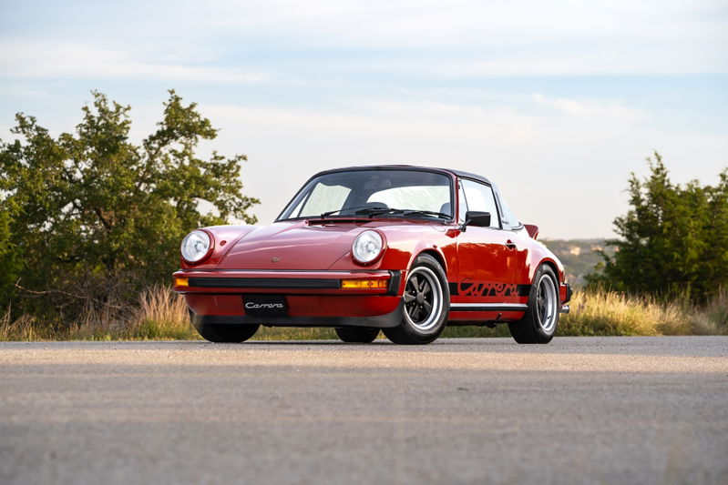 Red 1974 Porsche 911 Carrera Targa with black Carrera side livery and Fuchs wheels.