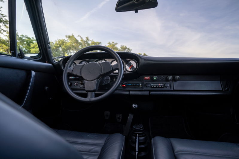 1974 Porsche 911 Carrera Targa interior. Black leather seats, dashboard, and steering wheel.