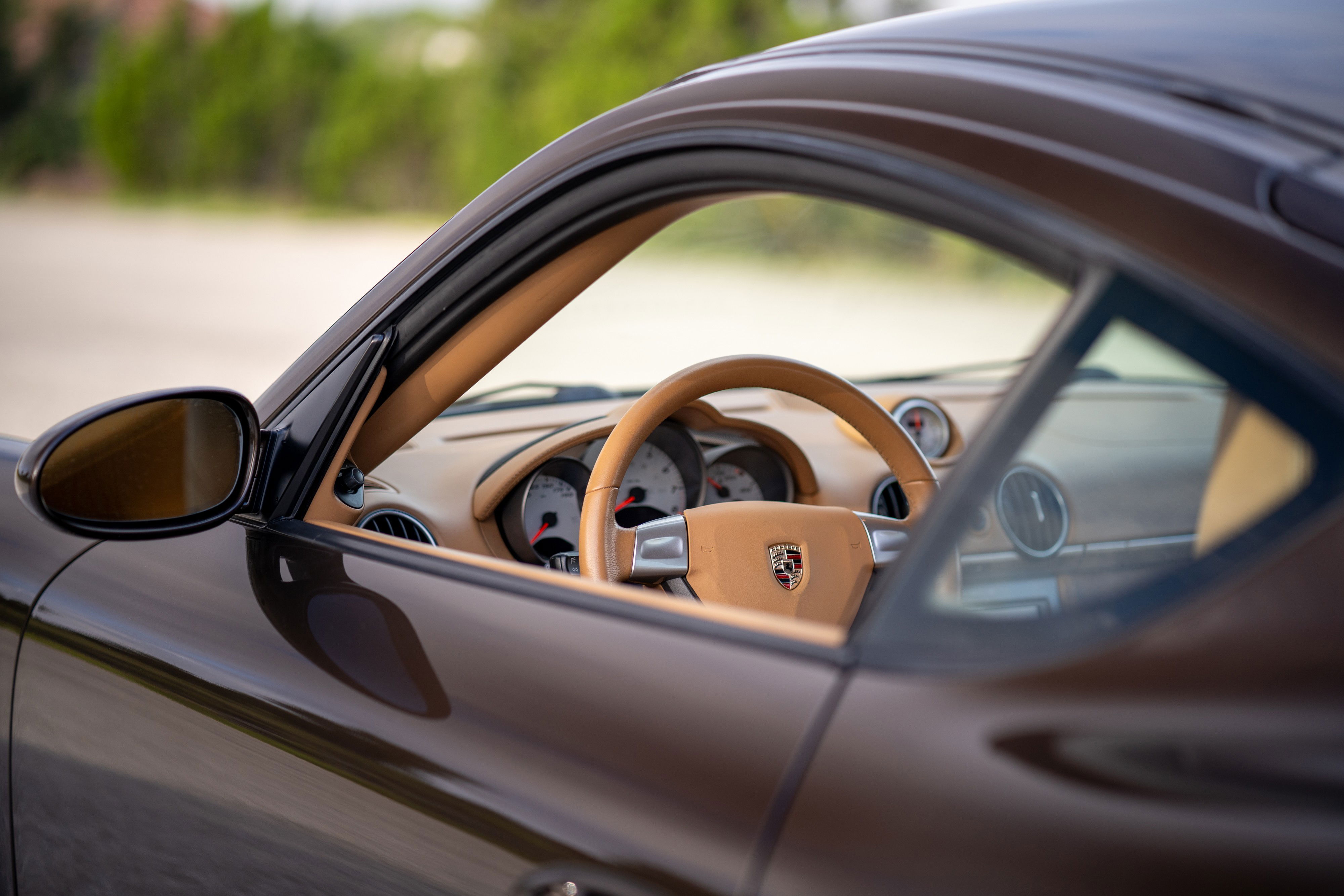 Brown 2008 Porsche Cayman S interior with tan leather trim and steering wheel.