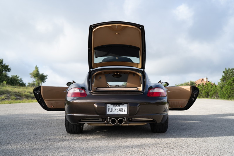 Macadamia Metallic 2008 Porsche Cayman S with open doors and trunk.