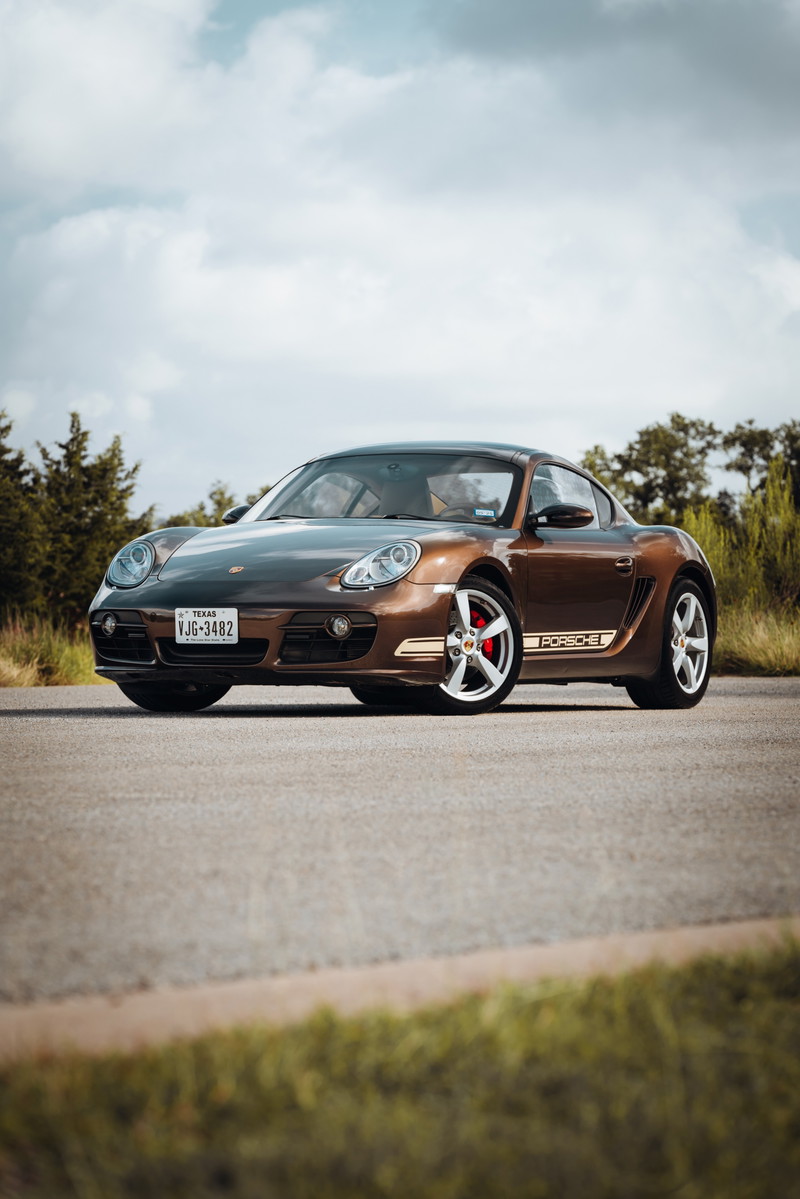 Front 3/4 view of a Macadamia Metallic 2008 Porsche Cayman S with unique side livery and red brake calipers.
