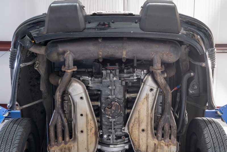 Underneath view of a black 1976 Porsche 911S Sportomatic showing engine and exhaust system.