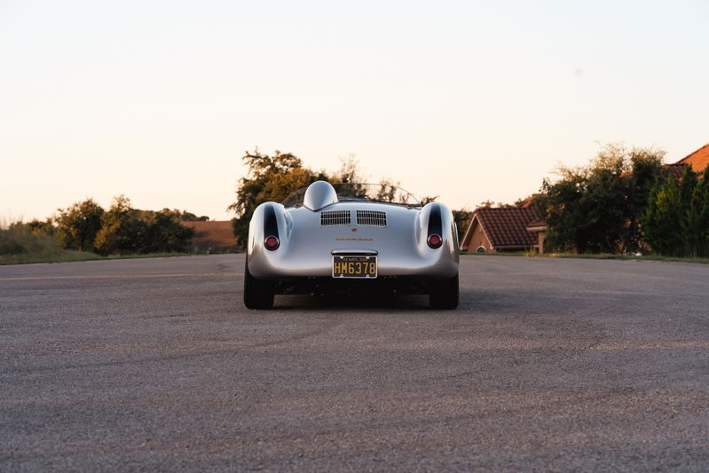 Rear view of a silver Beck 550 Spyder with gold California plates.