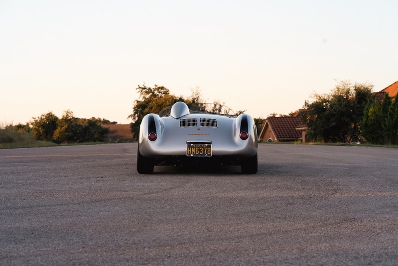 Rear view of a silver Beck 550 Spyder with gold California plates.