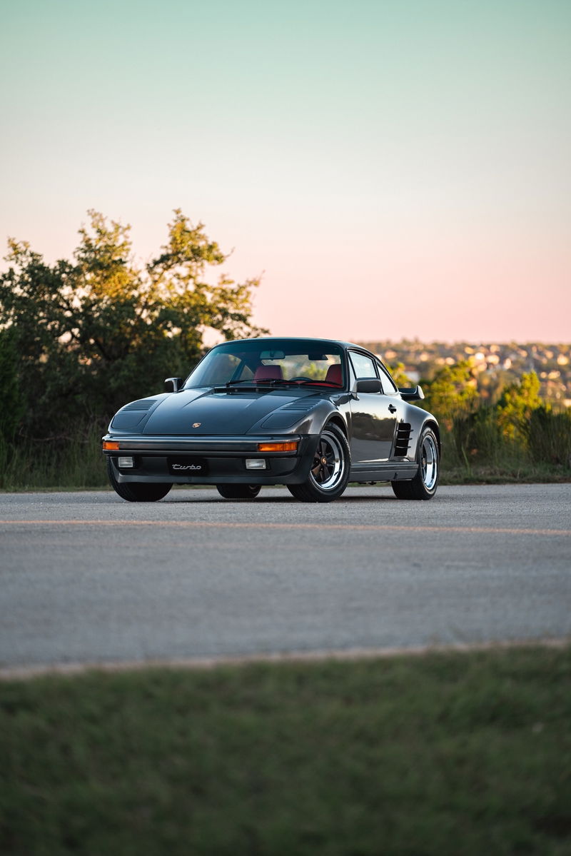 Slate grey metallic 1989 Porsche 930 Turbo Flachbau with red interior and Fuchs rims.