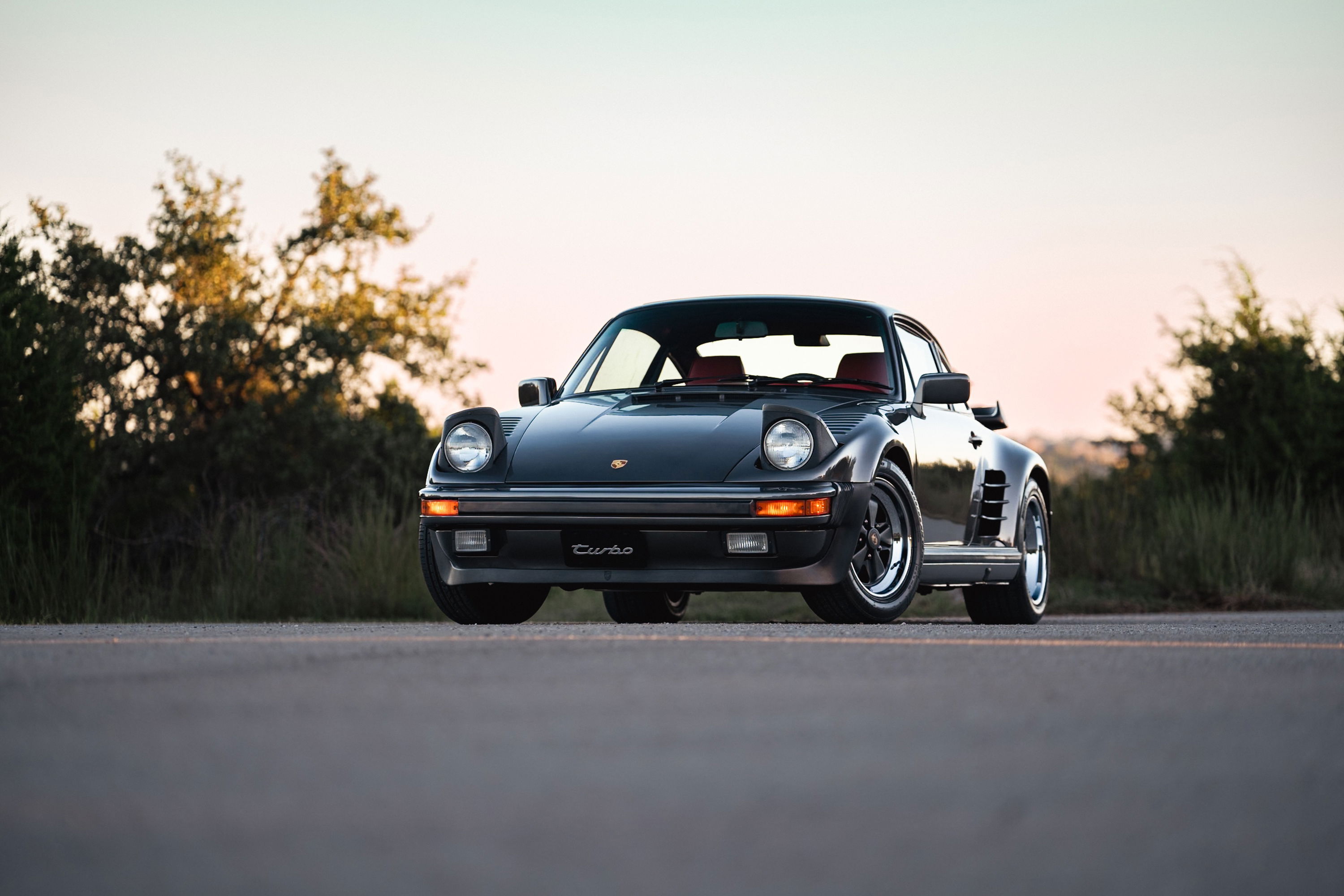 Slate grey metallic 1989 Porsche 930 Turbo Flachbau with red interior and Fuchs rims.