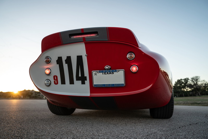 Rear view of a red 1965 Superformance Shelby Daytona with racing livery and number 114.