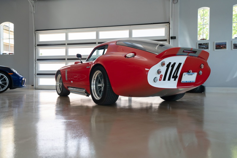 Red 1965 Superformance Shelby Daytona CSX with racing livery, custom rims, and a prominent "114" number plate.