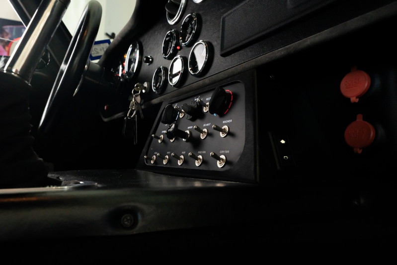 1965 Superformance Shelby Daytona in Monza Red: Close-up of the dashboard with toggles and gauges.