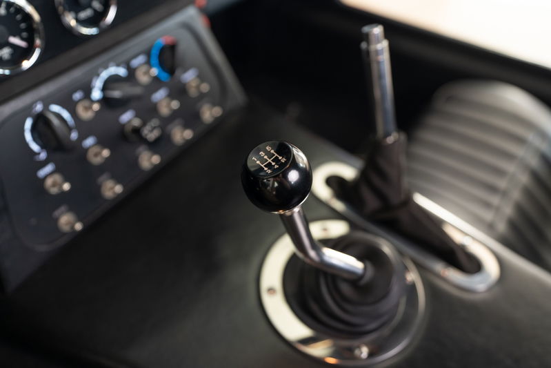 1965 Superformance Shelby Daytona CSX in Monza Red, interior view of the manual shifter and dash switches.