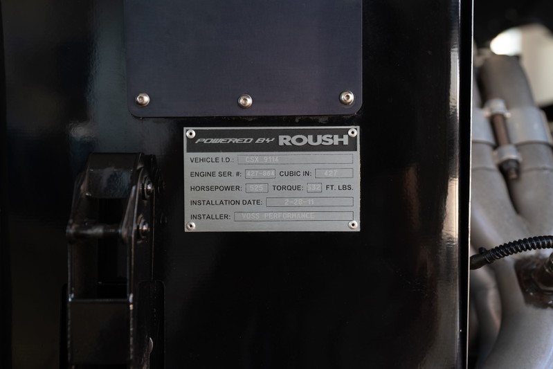 Close-up of a Roush Performance VIN plate on a red 1965 Shelby Daytona CSX.