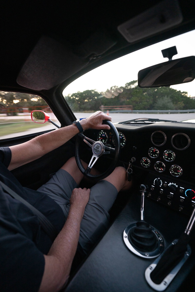 Driver's view of a red 1965 Superformance Shelby Daytona Coupe interior with a banjo steering wheel & shifter.