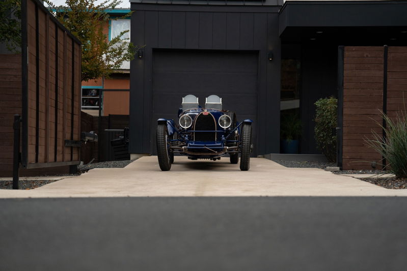 Front view of a dark blue 1927 Bugatti Type 35 Pur Sang with classic rims and chrome trim.