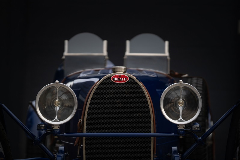 Close-up of the front of a blue 1927 Bugatti Type 35 Pur Sang. Features iconic grille and headlights.