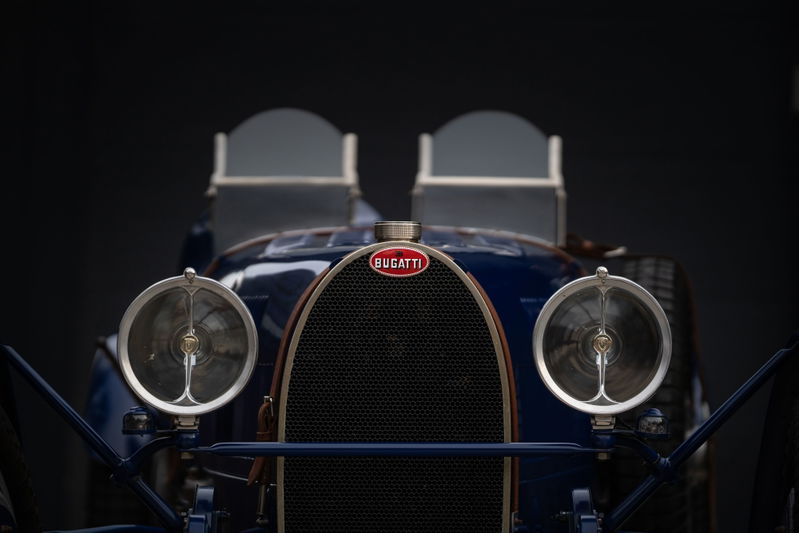 Close-up of the front of a blue 1927 Bugatti Type 35 Pur Sang. Features iconic grille and headlights.