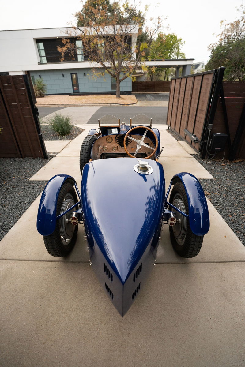 Front view of a blue 1927 Pur Sang Bugatti Type 35, showcasing its classic body and wire-spoke rims.