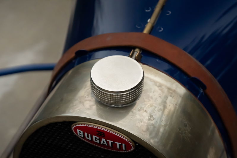 Close-up of a blue 1927 Bugatti Type 35 with a chrome fuel cap and vintage Bugatti badging.