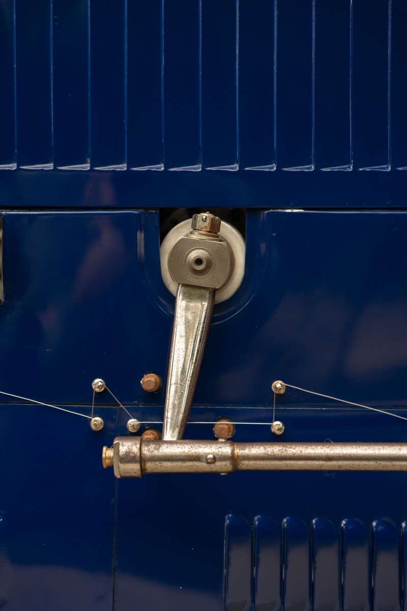 Close-up of a metal lever and cable system on a blue 1927 Bugatti Type 35 Pur Sang.