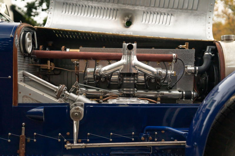 1927 Bugatti Type 35 engine bay, showcasing the intake manifold and exhaust headers on this blue classic race car.