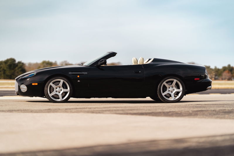 Black 2003 Aston Martin DB AR1 Zagato convertible, showing its five-spoke rims and cream interior.