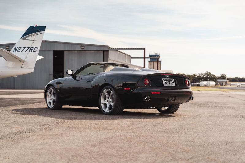 2003 black Aston Martin DBAR1 Zagato convertible with silver rims on an airport tarmac.