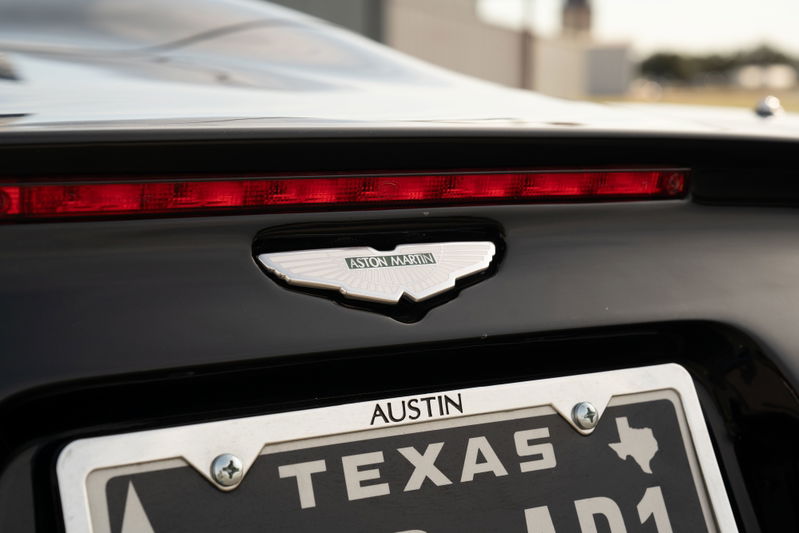 Rear view of a black 2003 Aston Martin DB AR1 Zagato with its badge and Texas license plate.