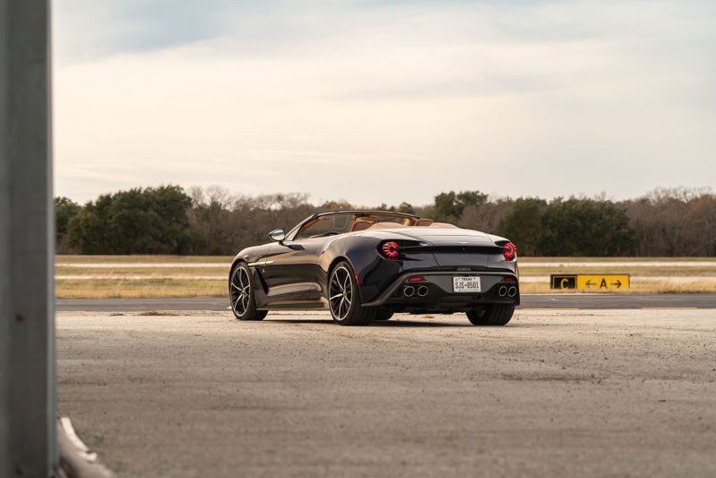 2018 Aston Martin Vanquish Zagato convertible in Orient Blue, showing rear 3/4 view, tan interior, black rims.
