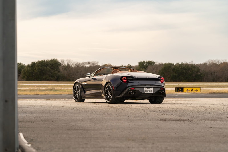 2018 Aston Martin Vanquish Zagato convertible in Orient Blue, showing rear 3/4 view, tan interior, black rims.