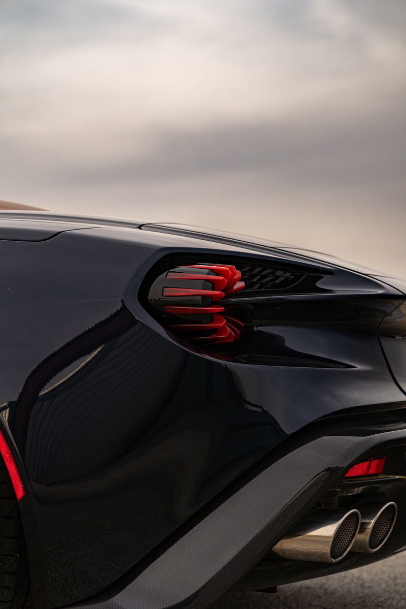 Close-up of an Aston Martin Vanquish Zagato's rear, featuring red taillight elements and carbon fiber trim.