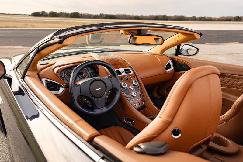 Interior view of a 2018 Aston Martin Vanquish Zagato, featuring tan leather upholstery and wood trim.