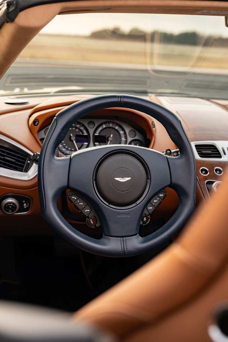 Interior of an Orient Blue 2018 Aston Martin Vanquish Zagato with tan leather trim and a dark blue steering wheel.