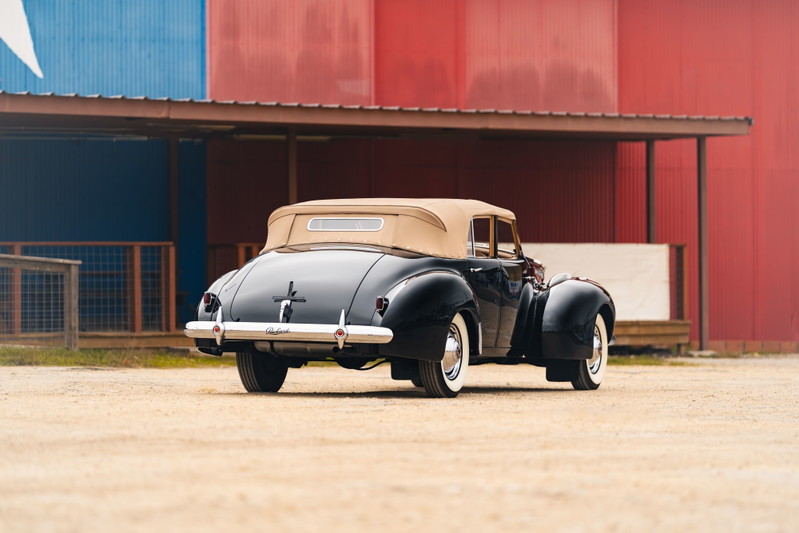 1940 Packard Super Eight One Eighty convertible in black with a tan top, white-wall tires, and chrome trim.