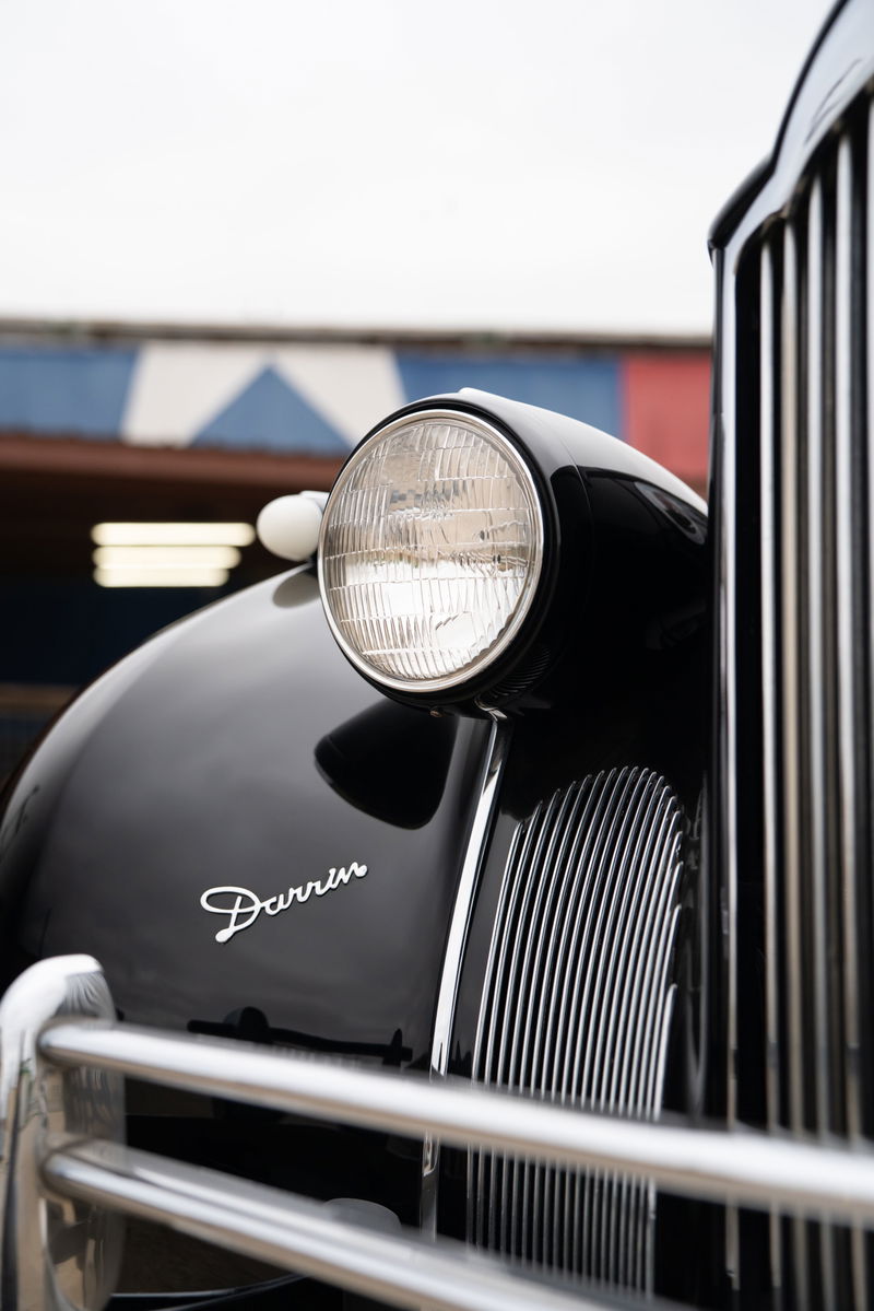 Close-up of a black 1940 Packard Super Eight One Eighty fender with a chrome grille and Darrin badging.