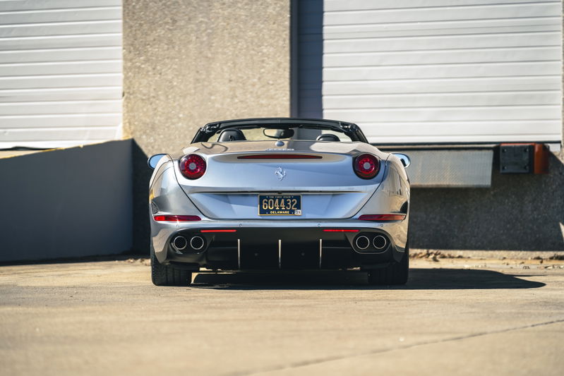 Rear view of a silver 2016 Ferrari California T with quad exhaust tips and black trim.