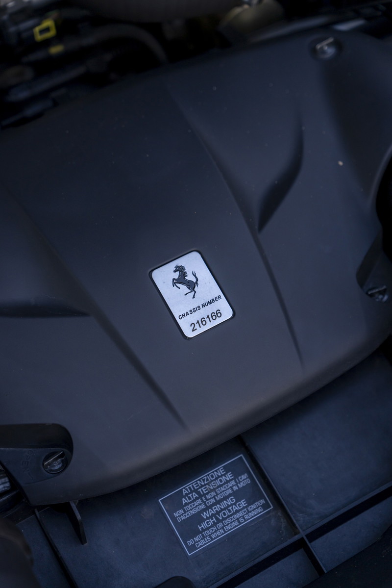 2016 Ferrari California T engine bay showing chassis number and high voltage warning sticker.