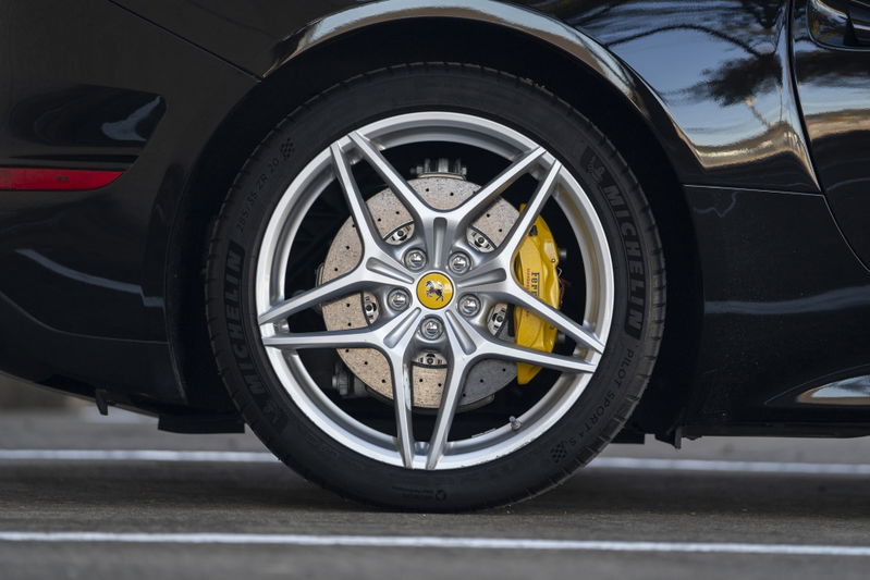 Close up of a silver Ferrari California T wheel with yellow brake calipers.
