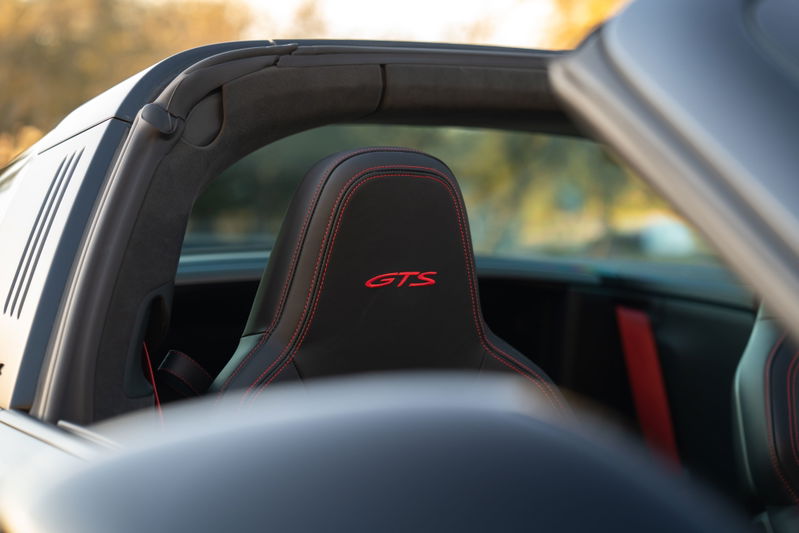 Interior view of a black 2023 Porsche 911 Carrera 4 GTS Targa with red GTS embroidery.