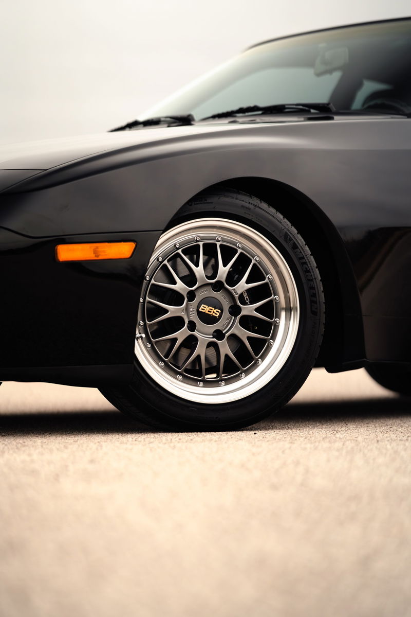 Black 1986 Porsche 944 Turbo front wheel with silver BBS rims.