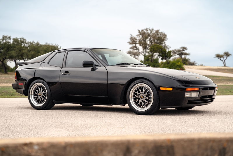 Black 1986 Porsche 944 Turbo with BBS rims and a rear spoiler.