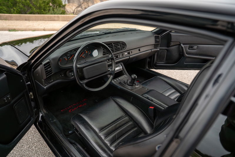Black 1986 Porsche 944 Turbo interior with leather seats and floor mats.