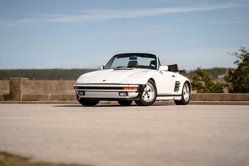 White 1988 Porsche 930 Turbo Slantnose convertible with Fuchs wheels and black soft top.
